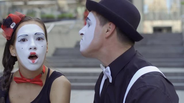 Young man and woman mimes gesticulating hands on camera