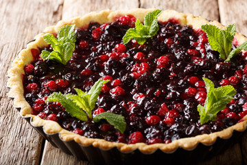 Homemade pie with summer berries and mint closeup in a baking dish on a table. horizontal