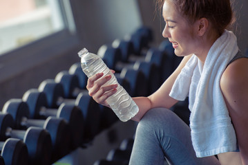 Portrait of sport woman drinking fresh clean water while exercising at fitness sport gym, thirsty after sport, enjoying, beauty and healthy concept.