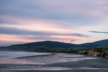 Beautiful scene of the beach with snow mountain at dusk.