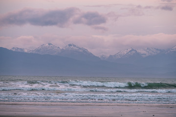 Beautiful scene of the beach with snow mountain at dusk.