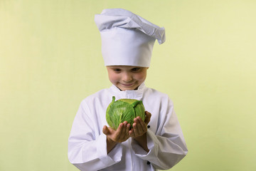 funny boy chef keeps in hands green cabbage