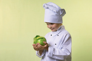 funny boy chef keeps in hands green cabbage