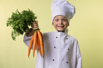 funny boy chef keeps in his hands a big carrot