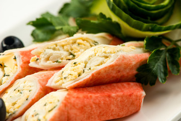 Crab sticks with lettuce and dill on brown wooden cutting board
