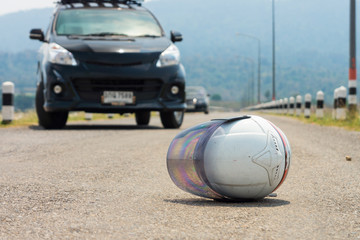 White motorcycle helmet and cars on road. Abstract of a road accident between vehicles.
