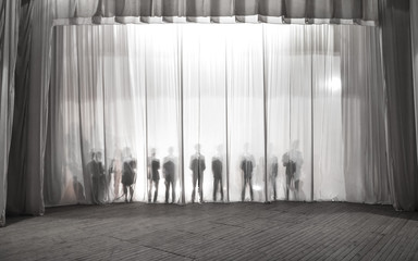 the silhouette of the men behind the curtain in the theater on stage, the shadow behind the scenes...