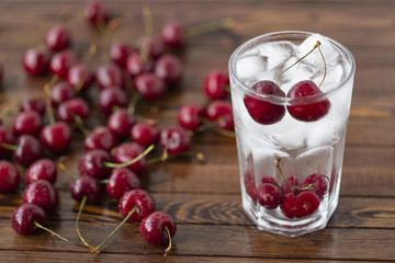 Summer iced drink -  cherry with ice. On rustic wooden table