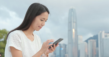 Woman look at smart phone in city