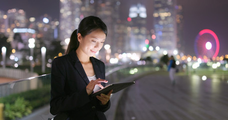 Businesswoman use of tablet computer at night