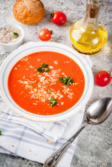 Tomato soup, Gazpacho in white bowl on grey stone background, with ingredients  Copy space