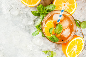 Cold summer drink. iced tea with lemon and mint, on grey stone background.  Copy space top view
