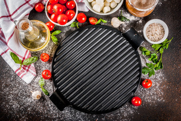 Homemade pasta pizza italian food ingredient on dark rusty table with flour, olive oil, basil, tomatoes and kitchen accessories top view