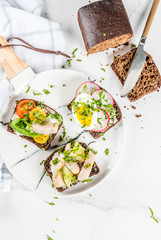 Set of various danish open sandwiches Smorrebrod with fish, egg and fresh vegetables, white marble background copy space top view