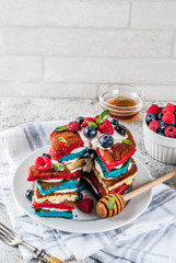 American Independence Day July 4th breakfast idea, homemade white blue red striped pancakes with fresh whipped cream, berry and honey, morning light grey stone background copy space