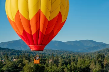Poster hot air balloon on beautiful sunny morning over wooded hills © just.b photography