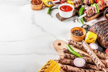 Assortment various barbecue food grill meat, bbq party fest - shish kebab, sausages, grilled meat fillet, fresh vegetables, sauces, spices, white marble background, above copy space