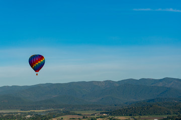 Fototapeta na wymiar Hot air balloon over wooded hills