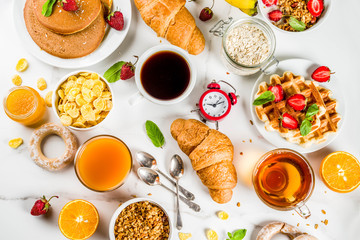 Healthy breakfast eating concept, various morning food - pancakes, waffles, croissant oatmeal sandwich and granola with yogurt, fruit, berries, coffee, tea, orange juice, white background - Powered by Adobe