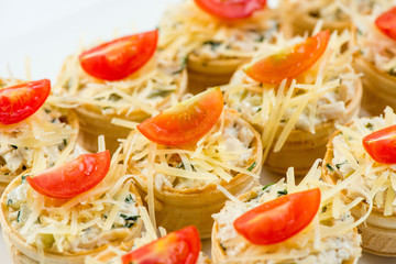 Three baguette slices with liver and apple pate and a thin tomato slice on top. Shallow DOF