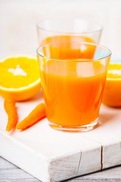 Glasses with carrot juice and sliced orange 