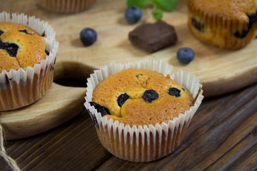 Muffins with blueberries, chocolate and cinnamon in a paper basket. Close up. Sweet dessert