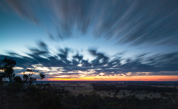 Long exposure of clouds moving across the landscape during sunset at the Black Ians Rocks near Grampians National Park, Australia.
