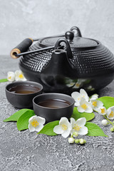 Obraz na płótnie Canvas Asian black traditional teapot and teacups with healthy green jasmine tea