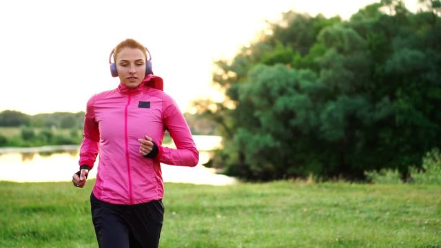 A morning jog in the Park near the pond in the Sunny rays of dawn, the girl is preparing to Mariano and lead a healthy lifestyle