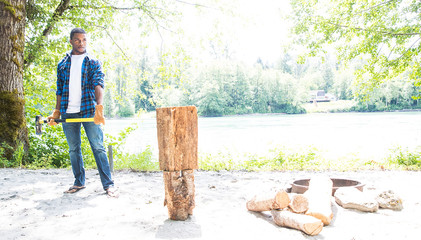 African American Man chopping wood in forest