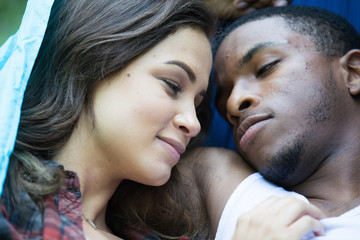 Mixed race couple laying down in hammock