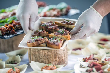 Chef preparing raw beef tartar mini breads on a catering event
