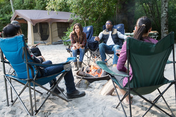 Group of friends camping on sandy beach