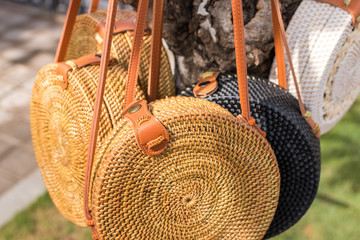Rattan handbags hanging on the tree closeup. Bali island. Tropical background. No people.