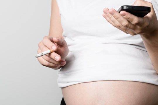 Pregnant woman smoking cigarette.