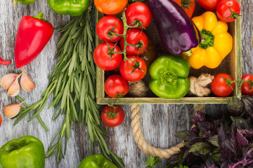 Set of different fresh raw colored vegetables in the wooden tray