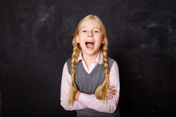 funny schoolgirl on blackboard background