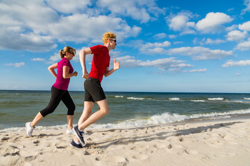Woman and man running on beach