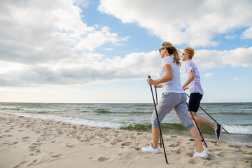 Nordic walking - man and woman training on beach