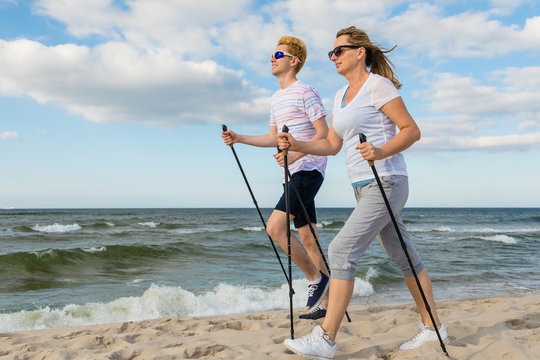 Nordic walking - man and woman training on beach