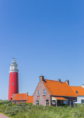 Fototapeta na wymiar Houses and red lighthouse on Texel island, The Netherlands