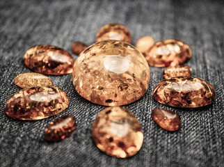 Artificial transparent amber cabochons on a black background closeup