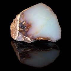 Natural polished opal stone on a black background