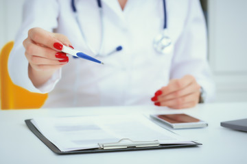 Female doctor's hands giving clinical thermometer. Healthcare personnel, medicine concept