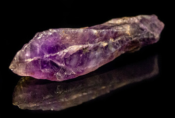 Natural untreated crystal of amethyst on a black background
