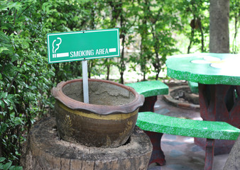 Smoking area sign on board with park bench