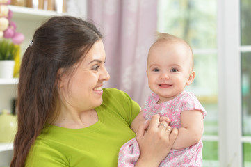 young woman with  baby girl at home