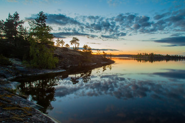 Dawn on the lake. The clouds are reflected in the water. Karelia. Ladoga lake. Nature of Russia. The Republic of Karelia.