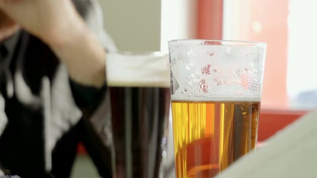 Close-up shot of two pints of beer standing on the table in a modern restaurant. 4K