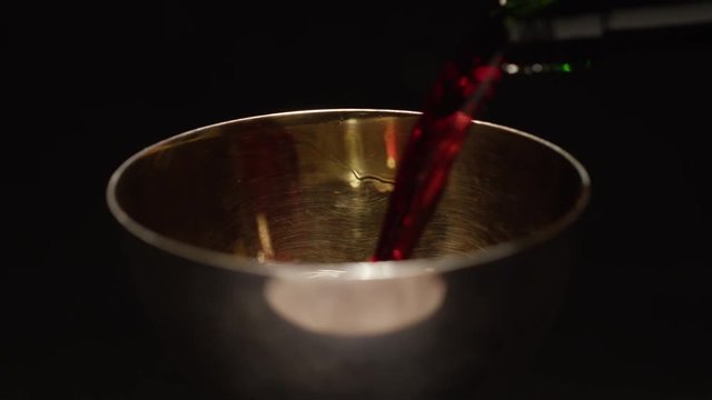 Filling golden cup with wine slow motion 